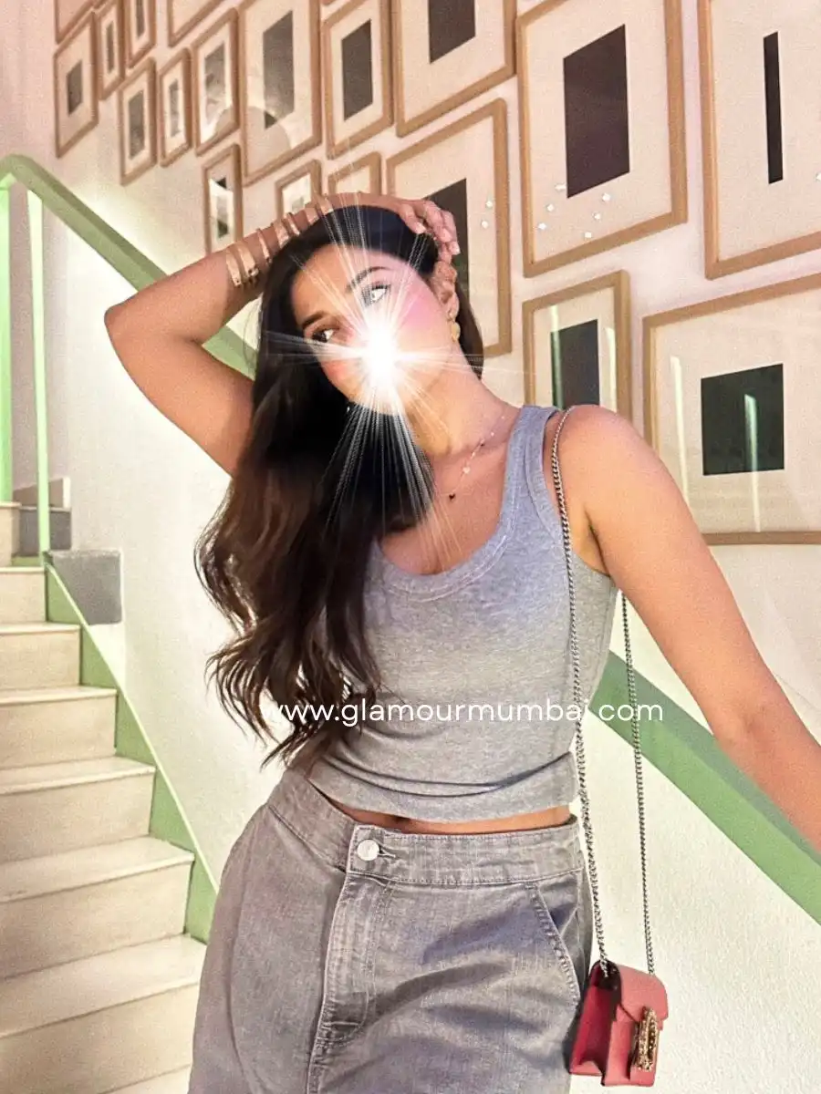 Exclusive Mumbai escort standing gracefully on staircase.